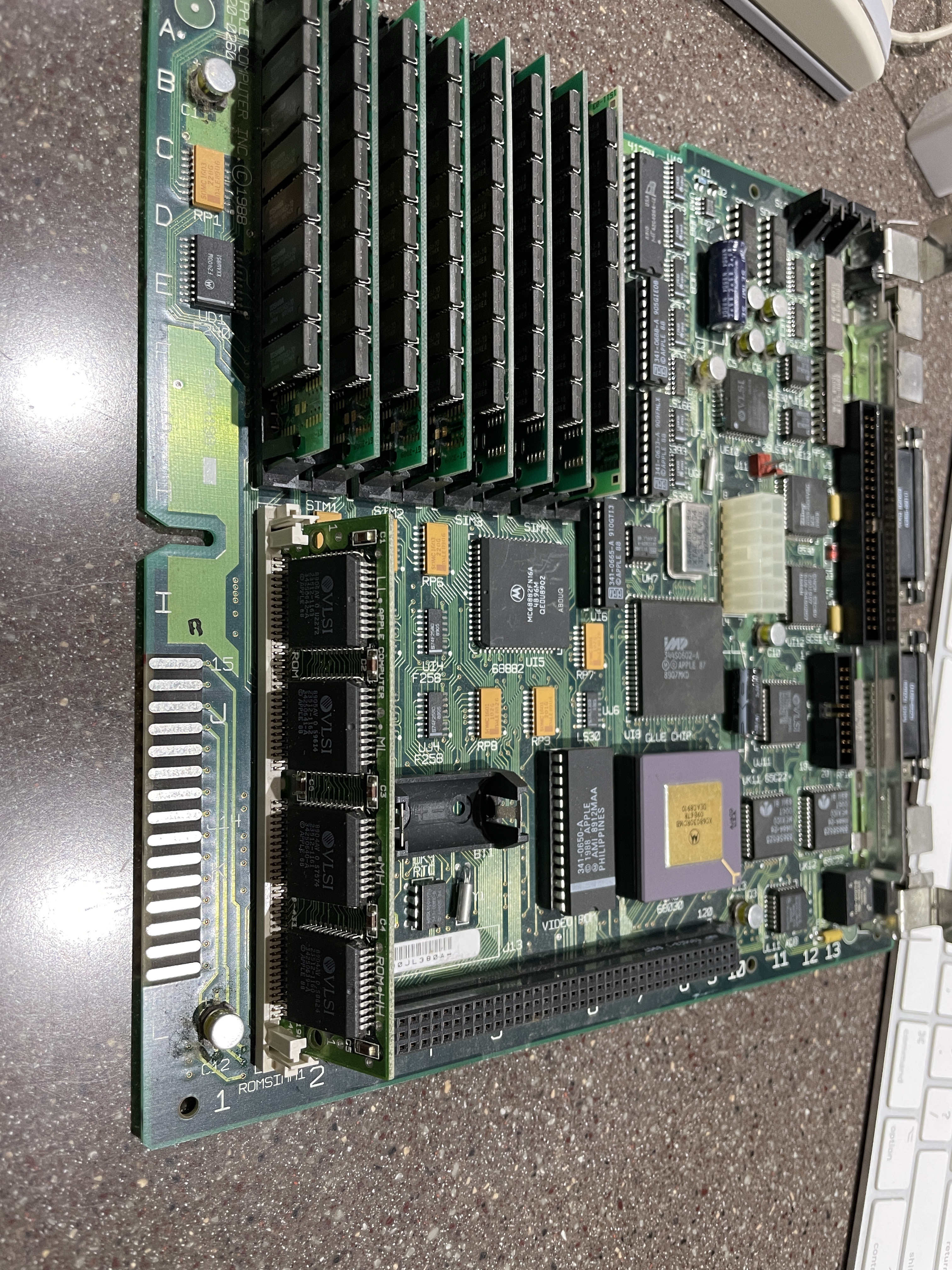 An SE/30 logic board removed from the case and laid flat, showing the RAM SIMM sockets, 68030 CPU, and coprocessor