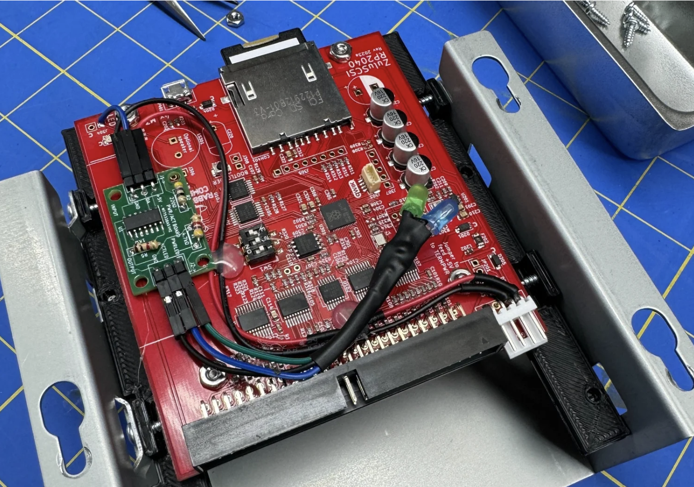 ZuluSCSI board mounted in a Sun drive bracket with the bi-color LED daughter card wired in
