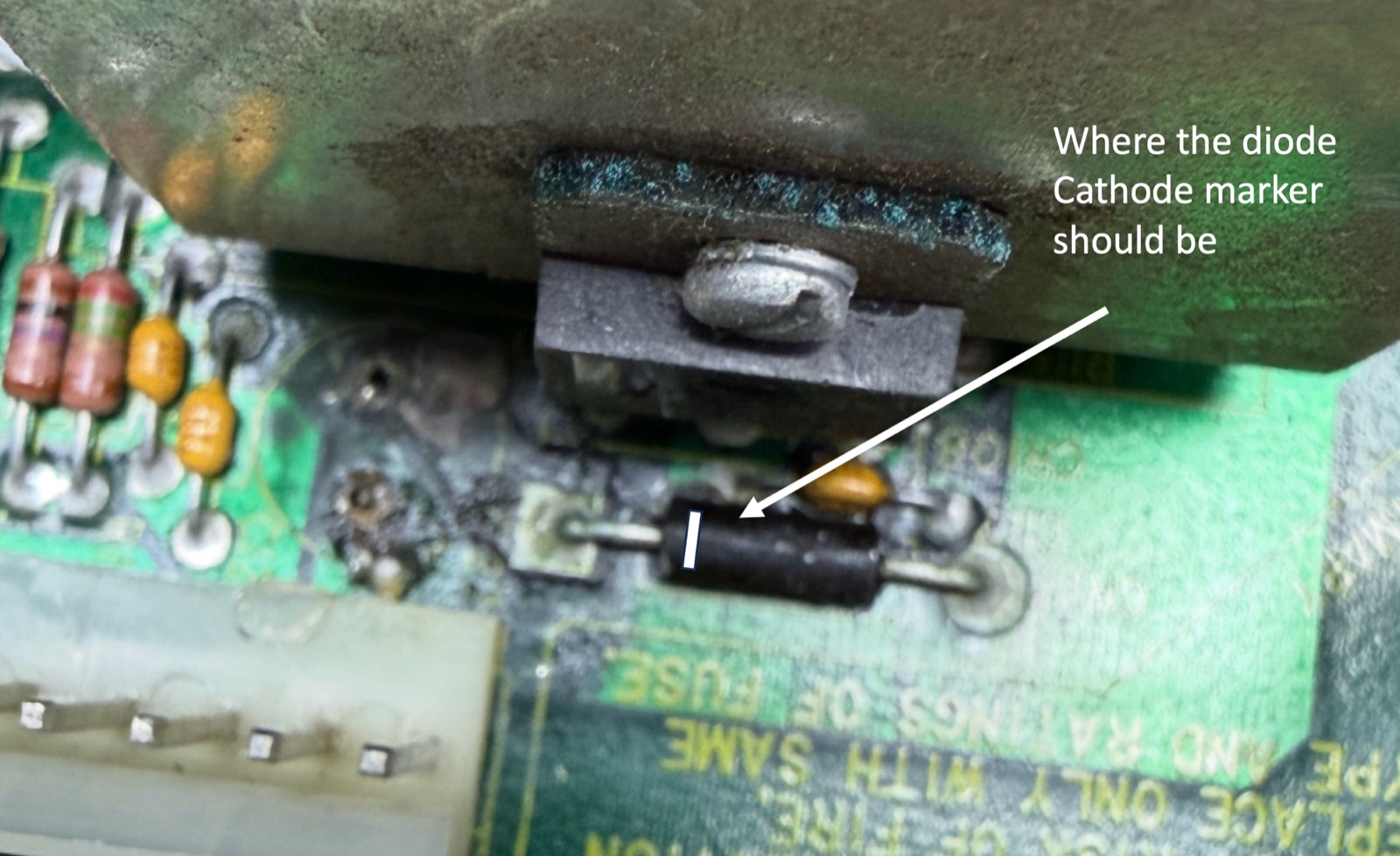 The failed CR111 zener diode in place on the main board, an unmarked black axial package, annotated with a drawn-in white band showing where the cathode marker should be